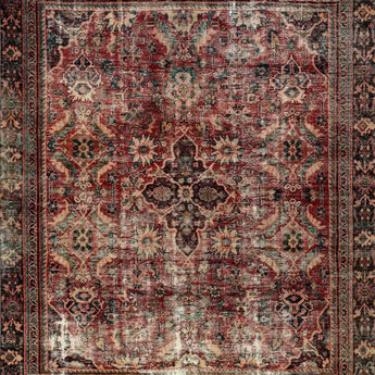 A vintage carpet in a red / purple color