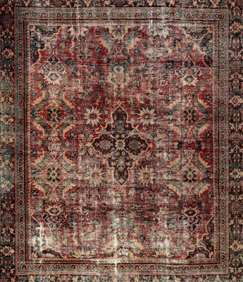 A vintage carpet in a red / purple color