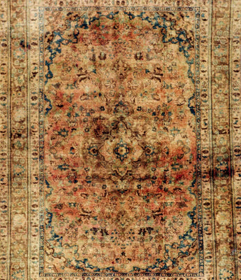 A yellow/orange stonwashed carpet with a classic motif in the middle